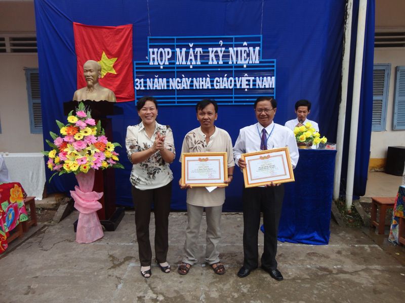 Đồng chí Đinh Thị Hồng Thắm trao giấy khen cho Nhà trường và Hội CMHS trường